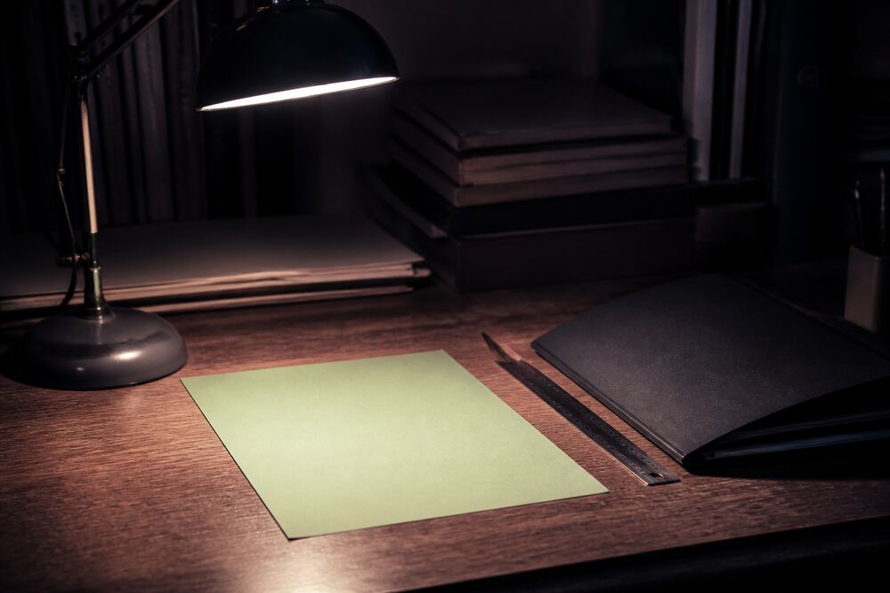 A paper calendar, note cards, and a blank planning ledger arranged in soft window light
